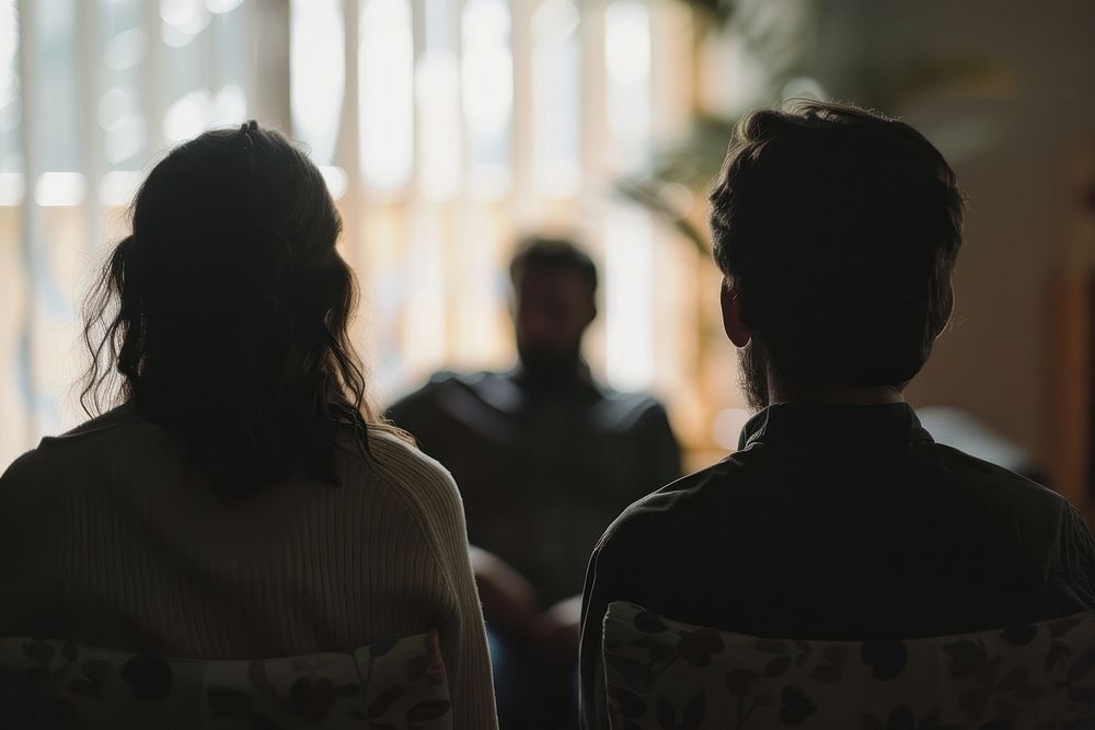 A married couple support each other during psychology therapy conversation silhouette female.