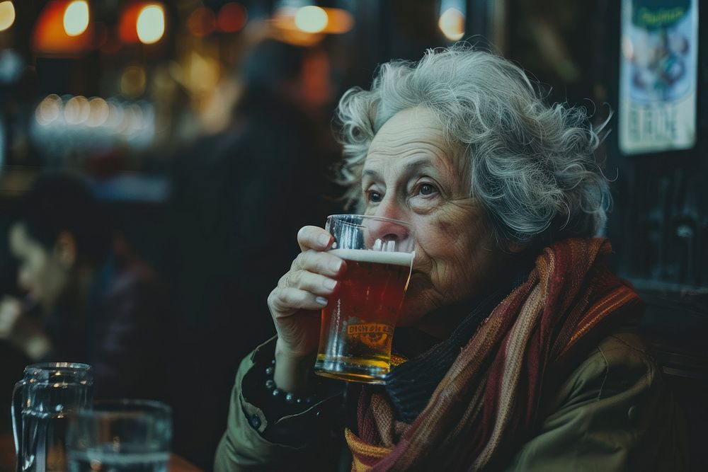 Mature woman drinking beer beverage.