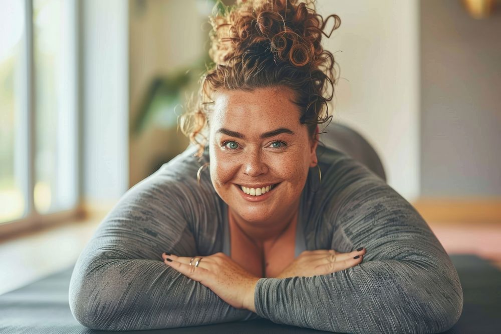 A happy chubby woman do yoga at home smile relaxation exercising.