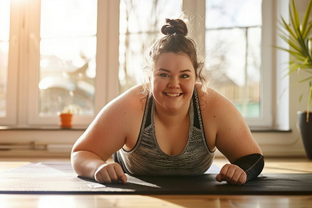 A happy chubby woman doing push up exercise sports determination.