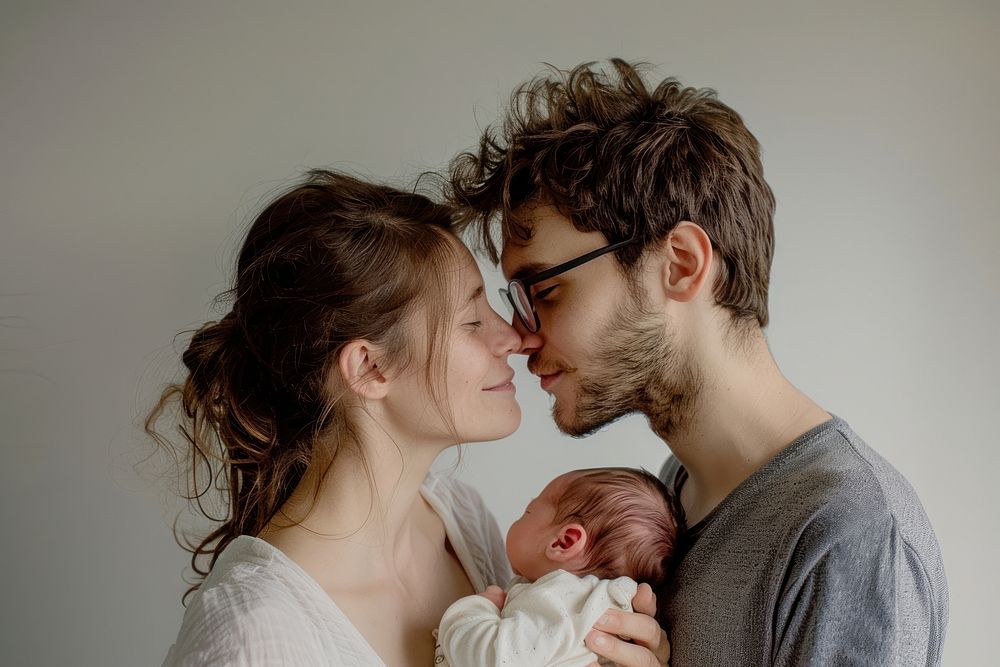 Happy young mother and father kissing with newborn portrait adult photo.