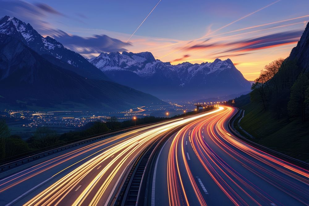 Cars speed light trails on a highway in the alps landscape mountain outdoors.