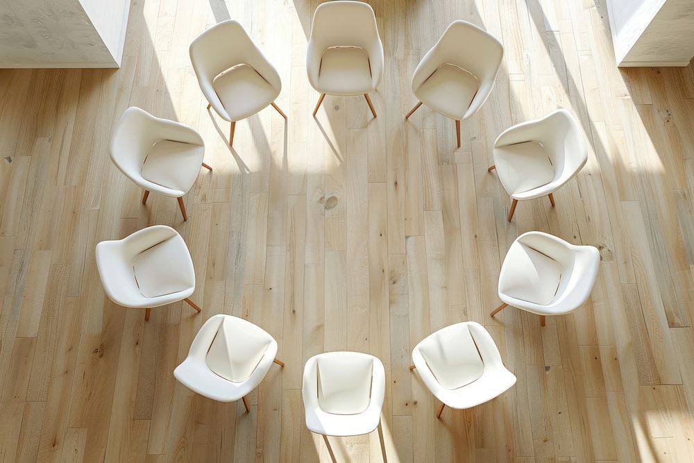Circle of 7 white chairs on beige wooden floor furniture armchair plywood.