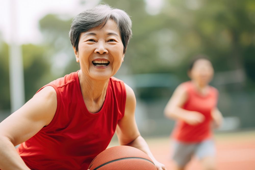 Sout east asian senior woman athletic basketball playing basketball laughing.