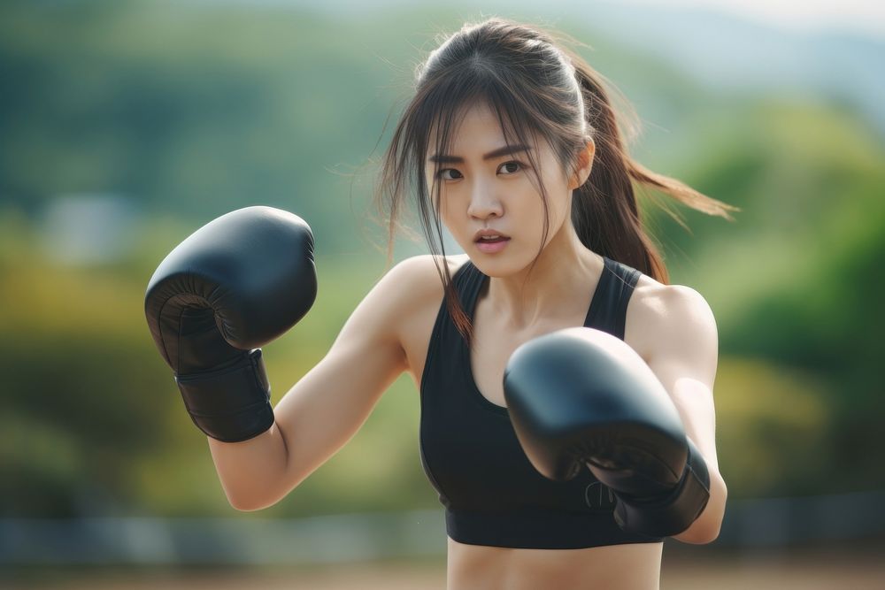 Sout east asian young woman athletic boxing punching person.