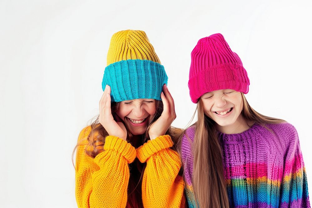 2 girls wear beanie sweater smile laughing.