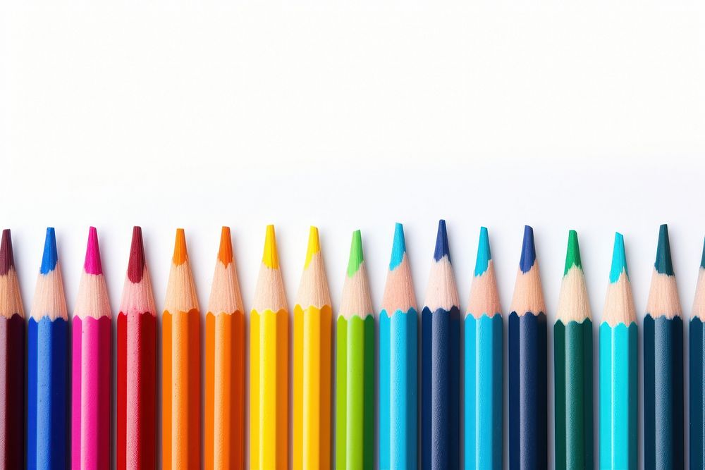 Colored pencils laying in row backgrounds order white background.