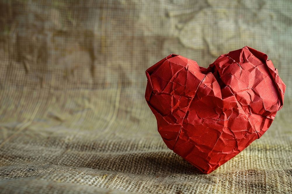 Heart in style of crumpled paper celebration pattern.