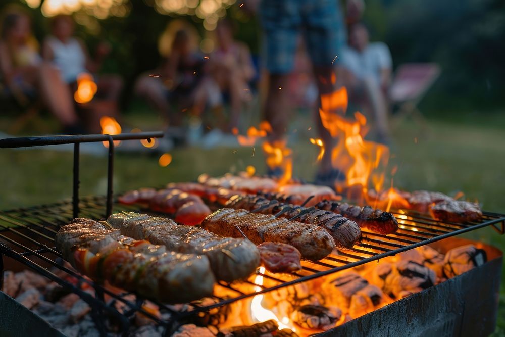 People party camping with BBQ grilling meat bbq cooking bonfire.