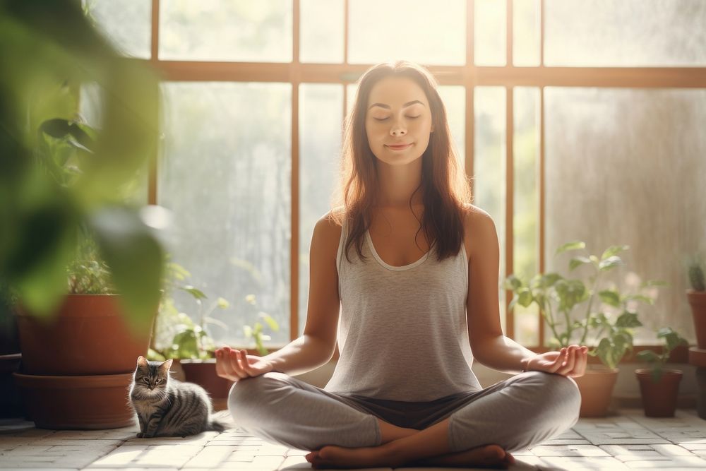 Young attractive smiling woman practicing yoga plant cat contemplation.