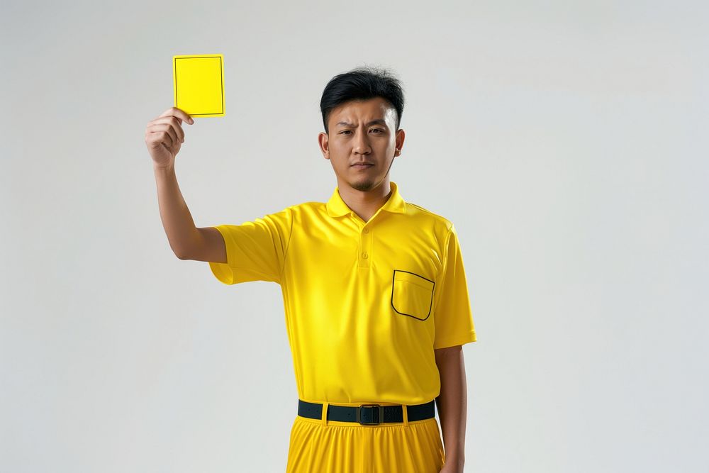 Photo of a referee showing a yellow card while holding it upwards adult white background happiness.