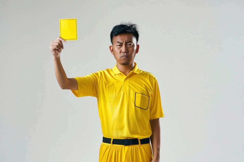 Photo of a referee showing a yellow card while holding it upwards adult white background happiness.
