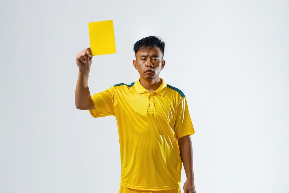 Photo of a referee showing a yellow card while holding it adult white background competition.