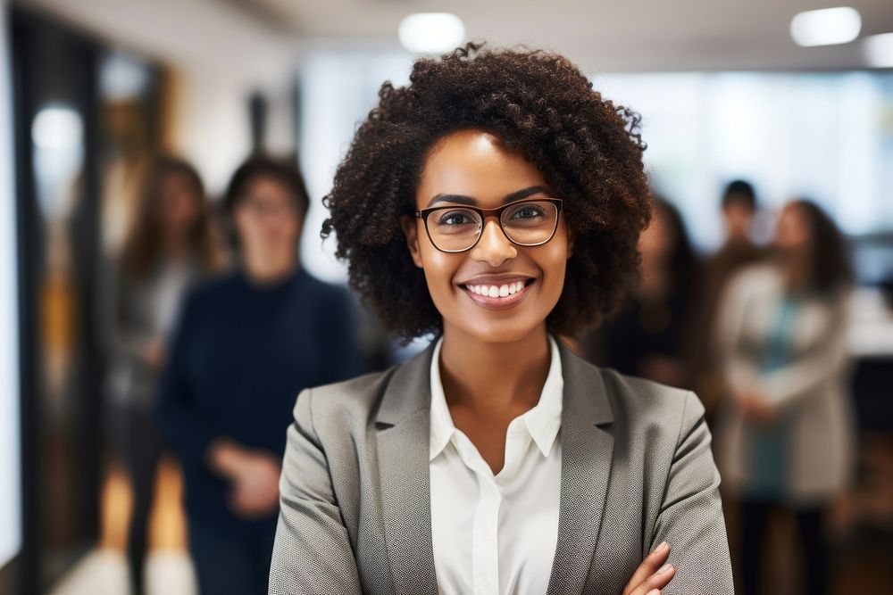 Smiling confident african businesswoman looking at camera and standing in an office at team meeting glasses smiling adult.