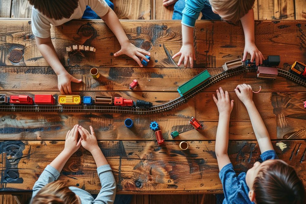 Kids playing with railroad and trains indoor indoors hardwood person.
