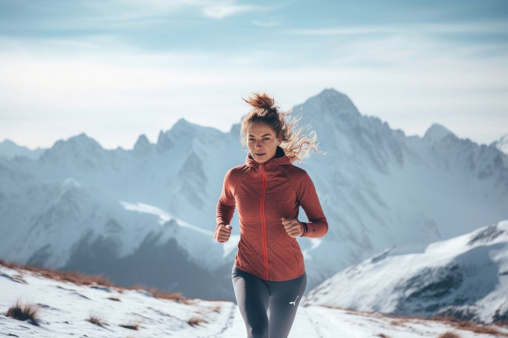 Woman wearing winter exercise clothes running mountain jogging.