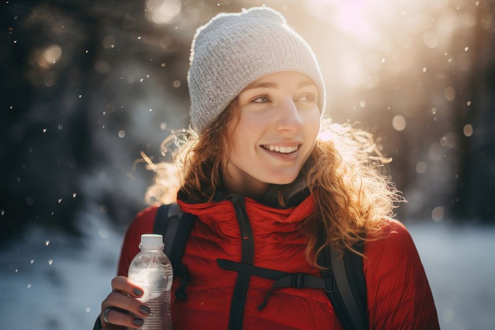 Woman drinking bottle of water snow portrait outdoors.