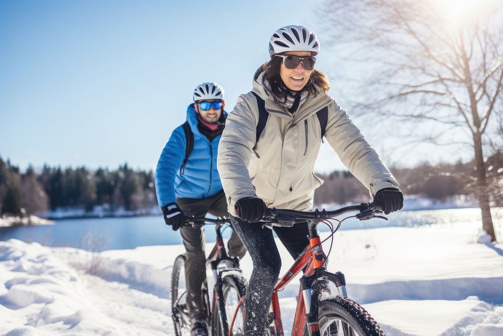 Couple biking through snow bicycle vehicle cycling.