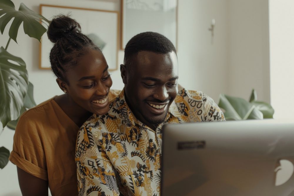 Man and woman looking at a computer electronics laughing person.