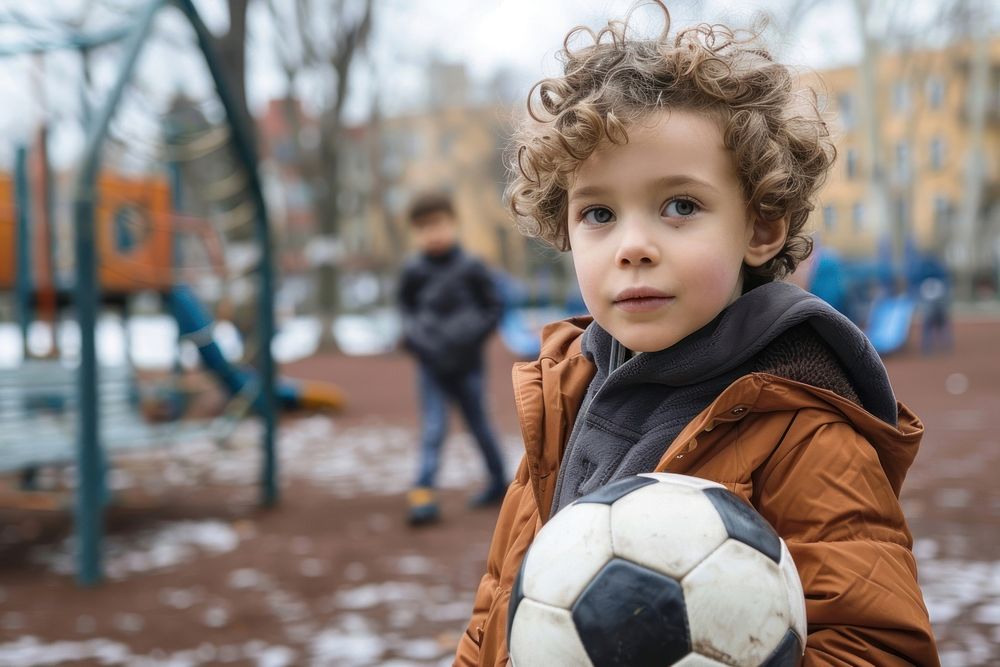 Kid holding soccer football clothing footwear.