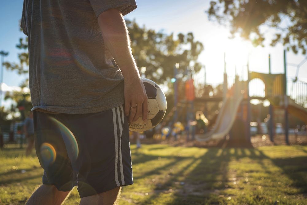 Man holding soccer playground volleyball outdoors.