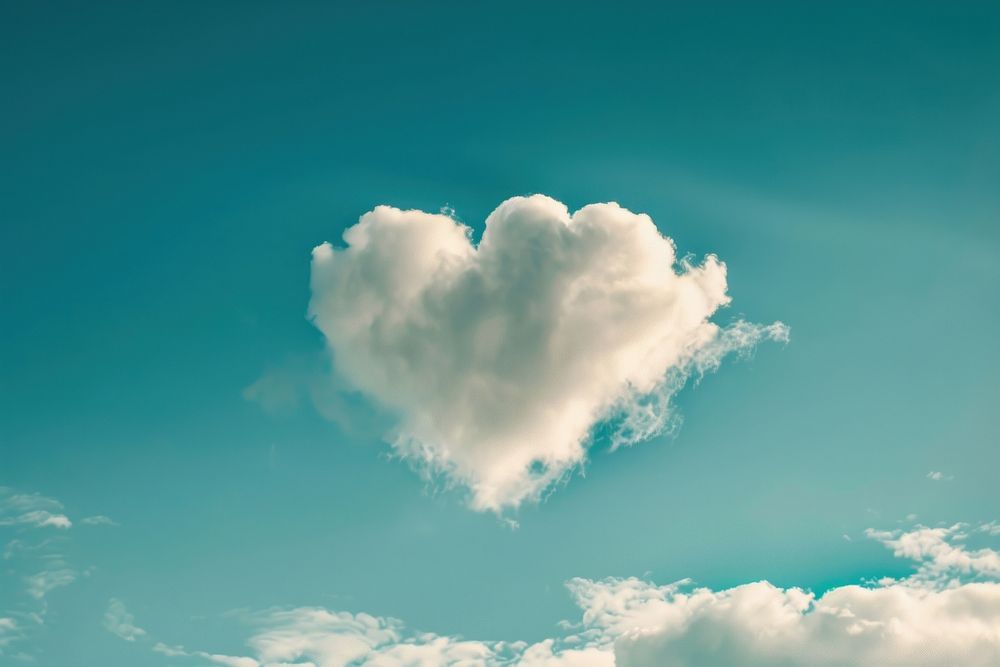 Heart shaped as a clouds in the blue sky background outdoors nature symbol.