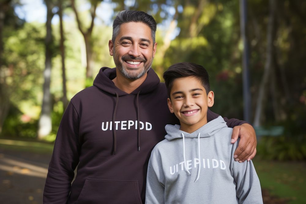 Smiling father and son sweatshirt photo park.