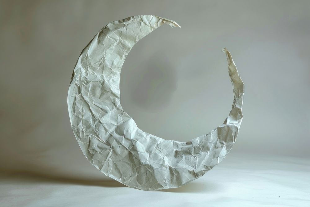 Crescent moon in style of crumpled paper astronomy sculpture.