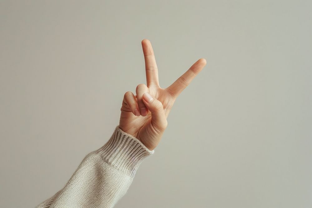Person making a peace sign finger human hand.