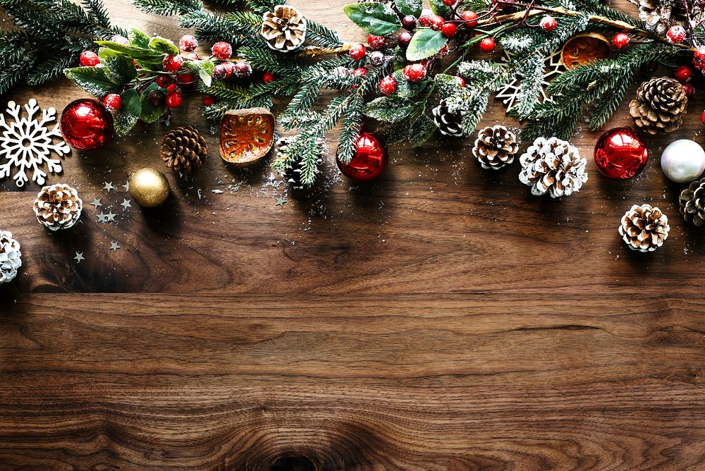 Festive Christmas decorations with pinecones, red ornaments, and greenery on a wooden table. Holiday with pinecones and…