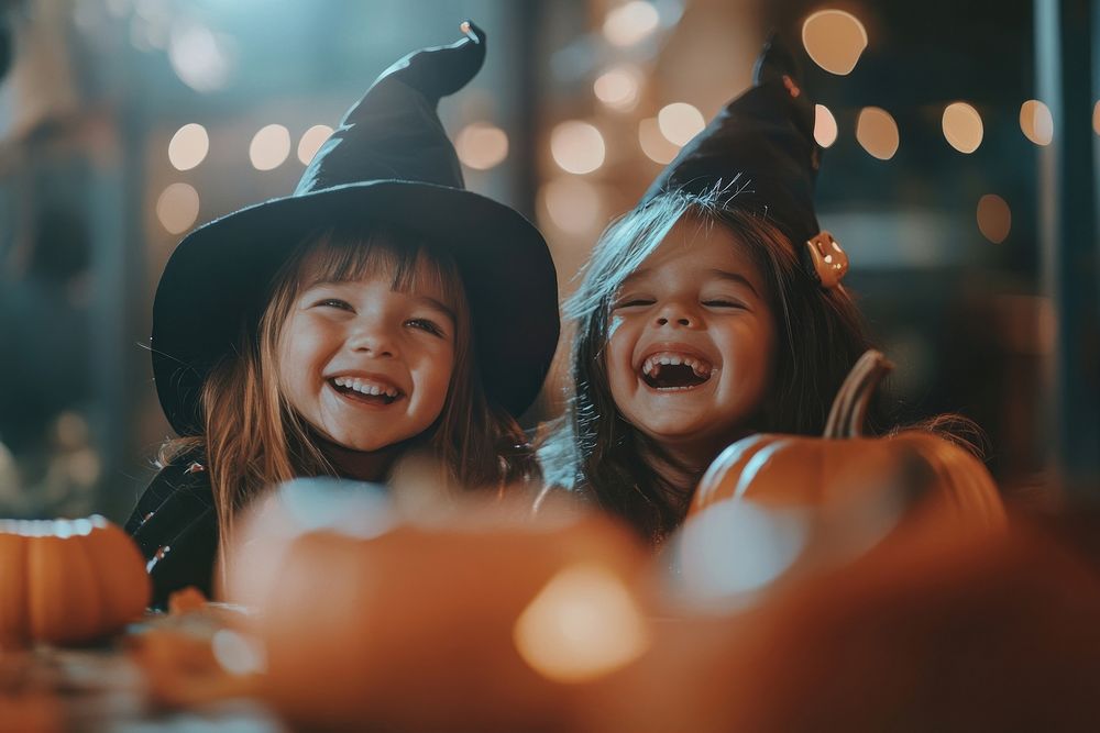 Two happy little latin kids in witch costumes halloween pumpkin celebration.