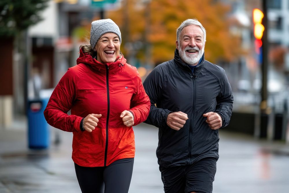 Elderly couple jogging outdoors happily.