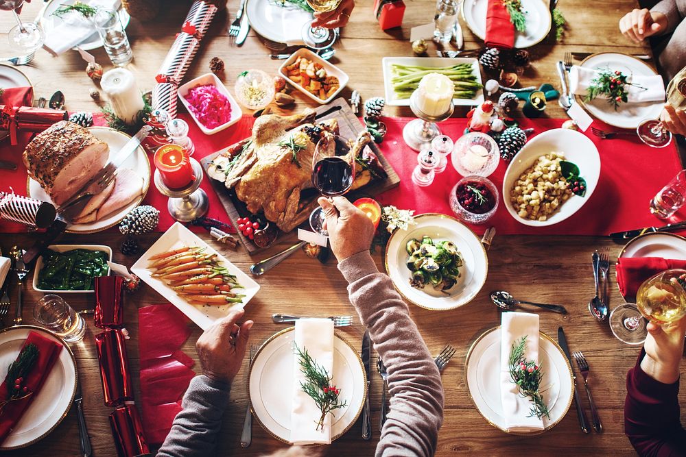 Top view of festive holiday dinner table with dishes, including turkey, vegetables, and desserts. A joyful Christmas…