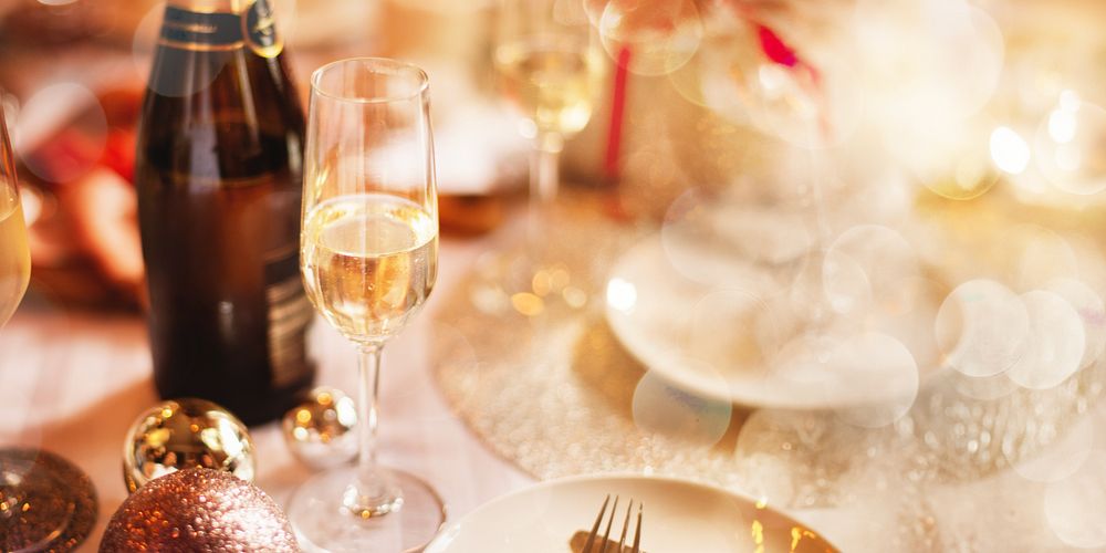 Festive dining table with champagne, glasses, sparkling decorations. Elegant champagne celebratory atmosphere. Champagne and…