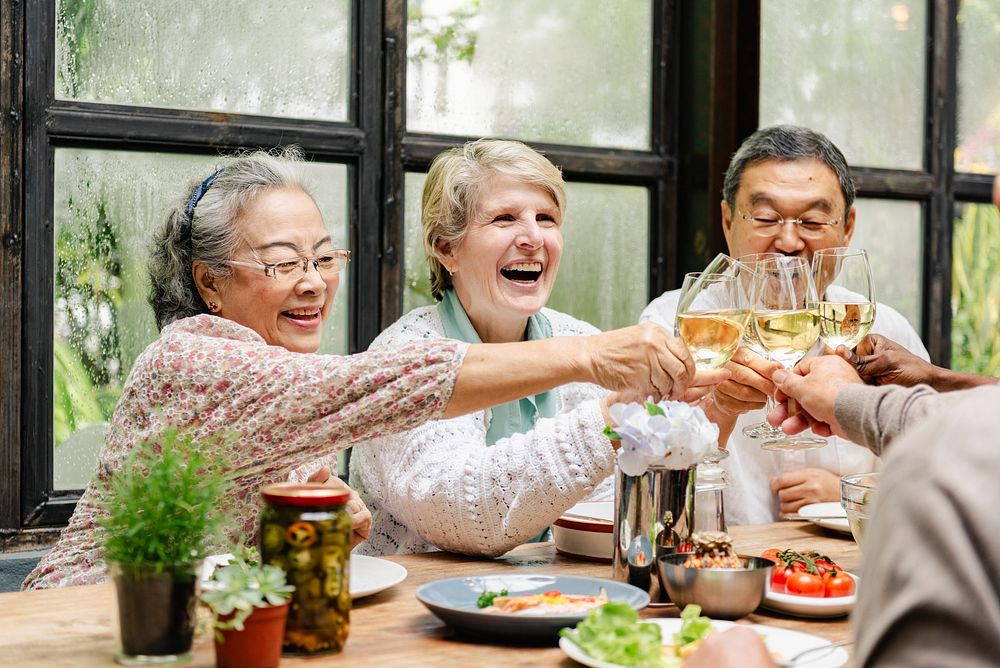 Group of senior enjoying a meal, toasting with wine. Diverse seniors, happy and smiling, sharing a joyful moment.…