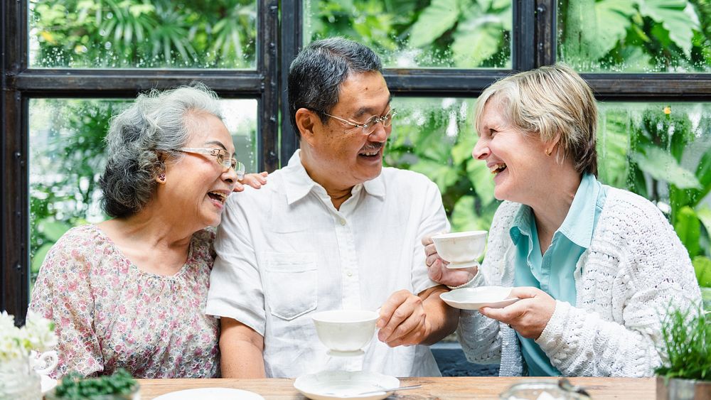 Three seniors enjoying tea and laughter. Diverse group of elderly friends sharing a joyful moment. Seniors, tea, and…