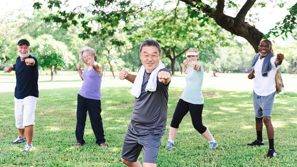 Group of diverse seniors exercise outdoors, healthy and energetic. Active diverse senior group enjoy fitness exercise in…