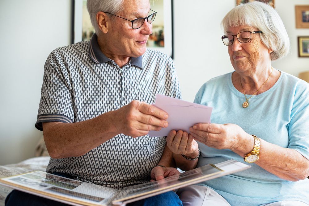 Elderly couple looking at photos. Senior man and woman sharing memories. Happy elderly couple enjoying time together. Senior…