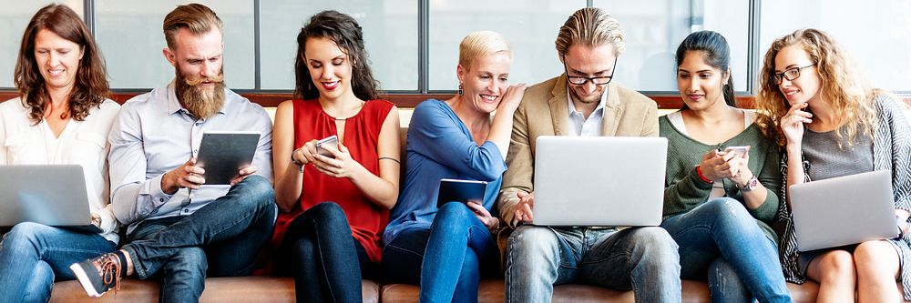 Diverse group of people using laptops and tablets. Diverse busines people engaged with technology, sitting together, sharing…