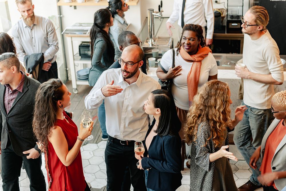 Diverse group of people at social event, mingling and chatting. Diverse crowd enjoy drinks and conversation in lively social…