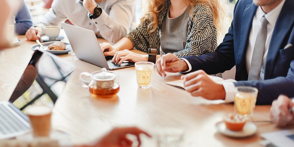 Group of business people in casual meeting, using laptops and taking notes. Business attire, diverse team, collaborative…