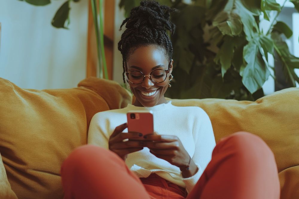 Smiling woman checking phone glasses plants accessories.