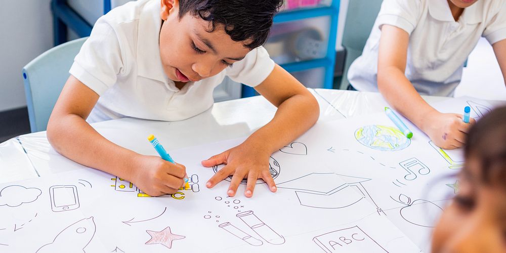 Children drawing at a table, focused on creativity. Kids in a classroom, engaged in art. Young students, art supplies, and…