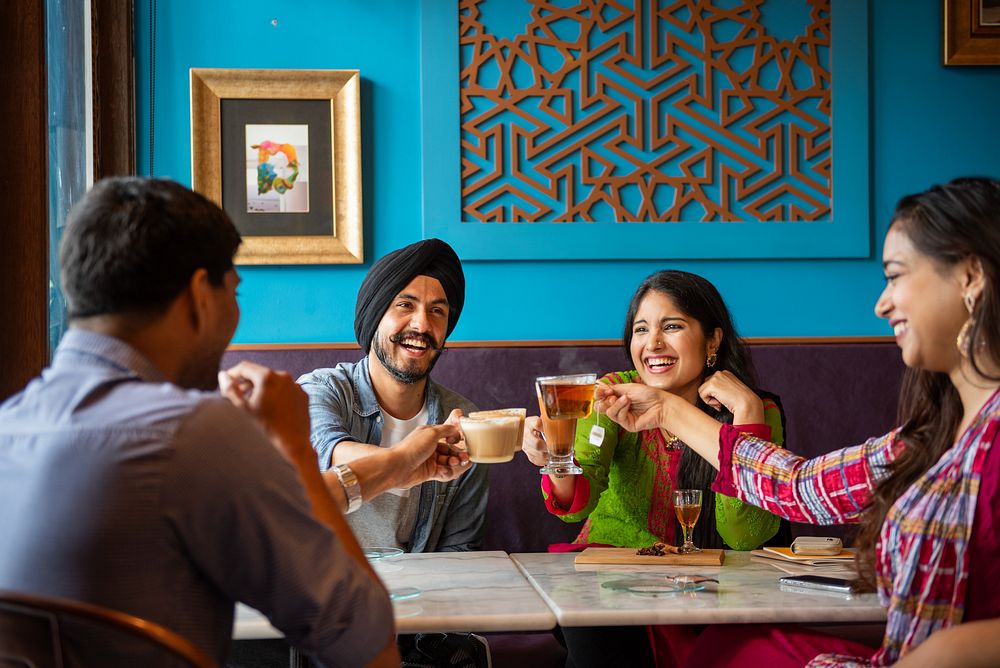 Group of South Asian friends enjoying drinks at a cafe. Smiling, chatting, and toasting. Happy moments, vibrant setting…