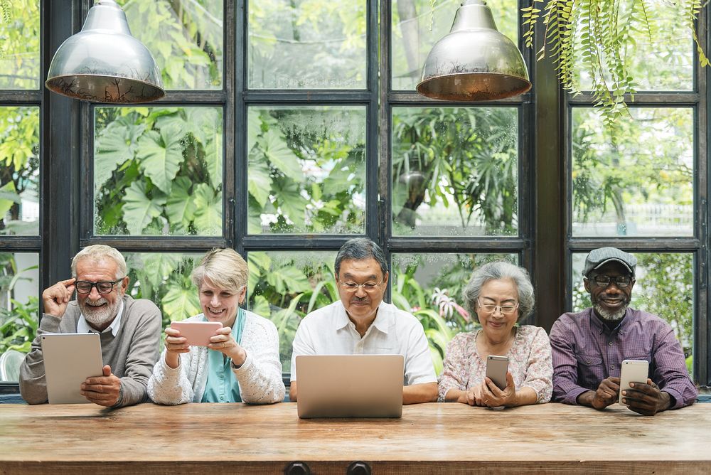 Diverse group of seniors using devices. Elderly men and women with tablets and laptops. Multicultural seniors enjoying…