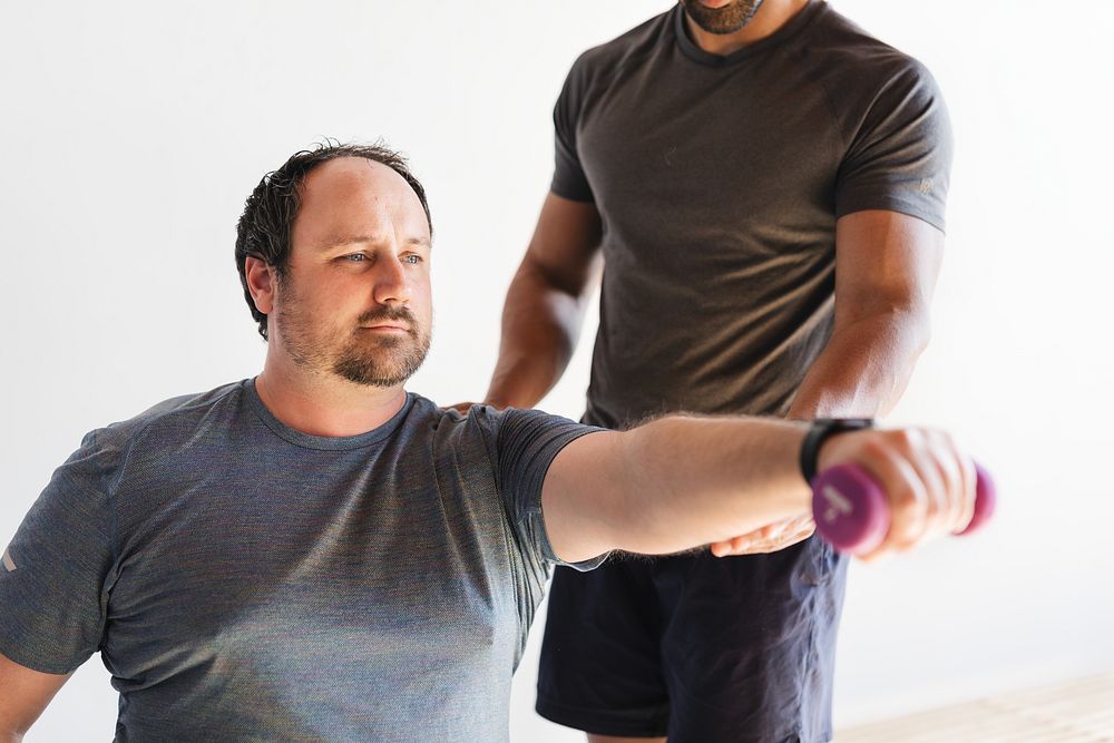 man exercises dumbbell, assisted trainer. | Free Photo - rawpixel