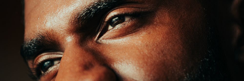 Close-up of a person's eyes and eyebrows, focusing on facial features and expression. The image highlights the texture and…