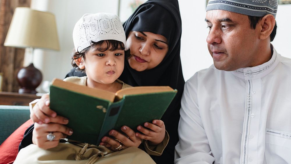 A family reading together. A child, mother, and father focus on a book. The family shares a moment of learning and bonding…