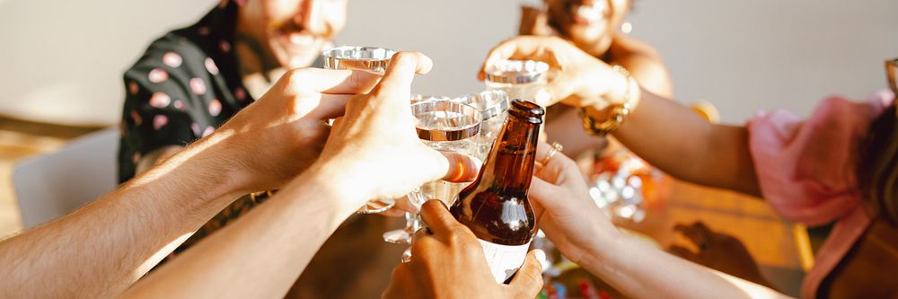 Group of people clinking glasses in celebratory toast. Diverse hands holding drinks, creating festive atmosphere. Cheers and…