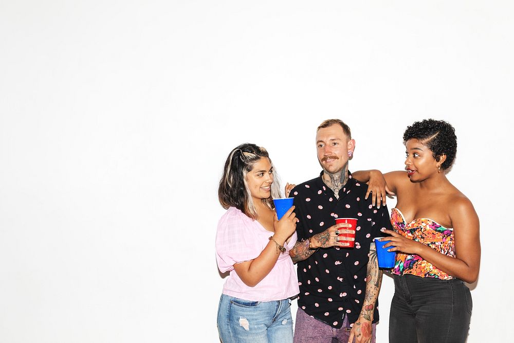 Three people enjoying a casual gathering. Two women and a man, diverse ethnicities, smiling, and chatting. Social, friendly…